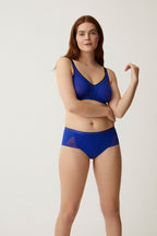 Voorzijde van vrouw die de minimizer bh met side smoother en slip met mesh detail in de kleur indigo  van het merk Naturana draagt