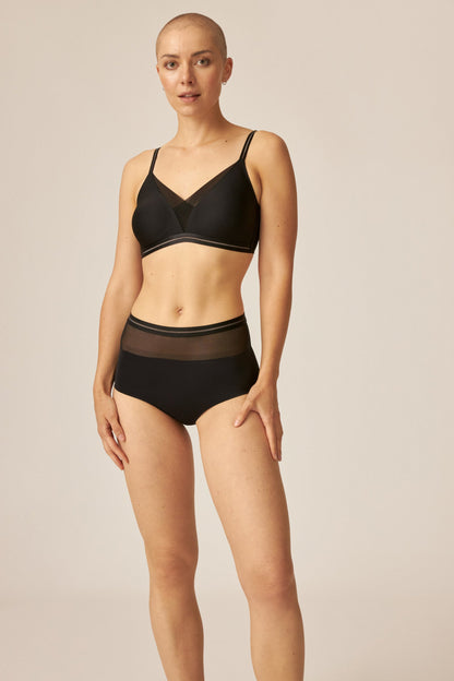 Voorzijde van vrouw die de soft bh met mesh detail en hoge slip met mesh detail in de kleur zwart van het merk Naturana draagt