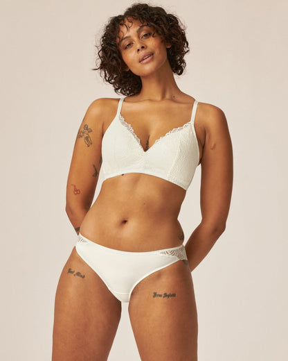 Voorzijde van vrouw die de soft bh met kant en de slip met kant in de kleur ecru van het merk Naturana draagt