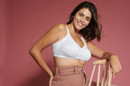 Zijde van vrouw die de minimizer bh met side smoother in de kleur wit van het merk Naturana draagt