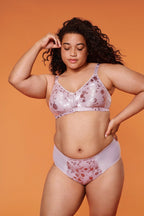 Voorzijde van vrouw die de minimizer bh met bloemenpatroon en slip met bloemenpatroon in de kleur Pearl van het merk Naturana draagt
