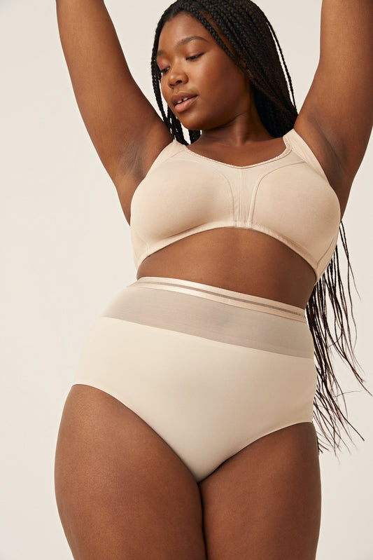 Voorzijde van vrouw die de hoge slip met mesh detail in de kleur beige van het merk Naturana draagt