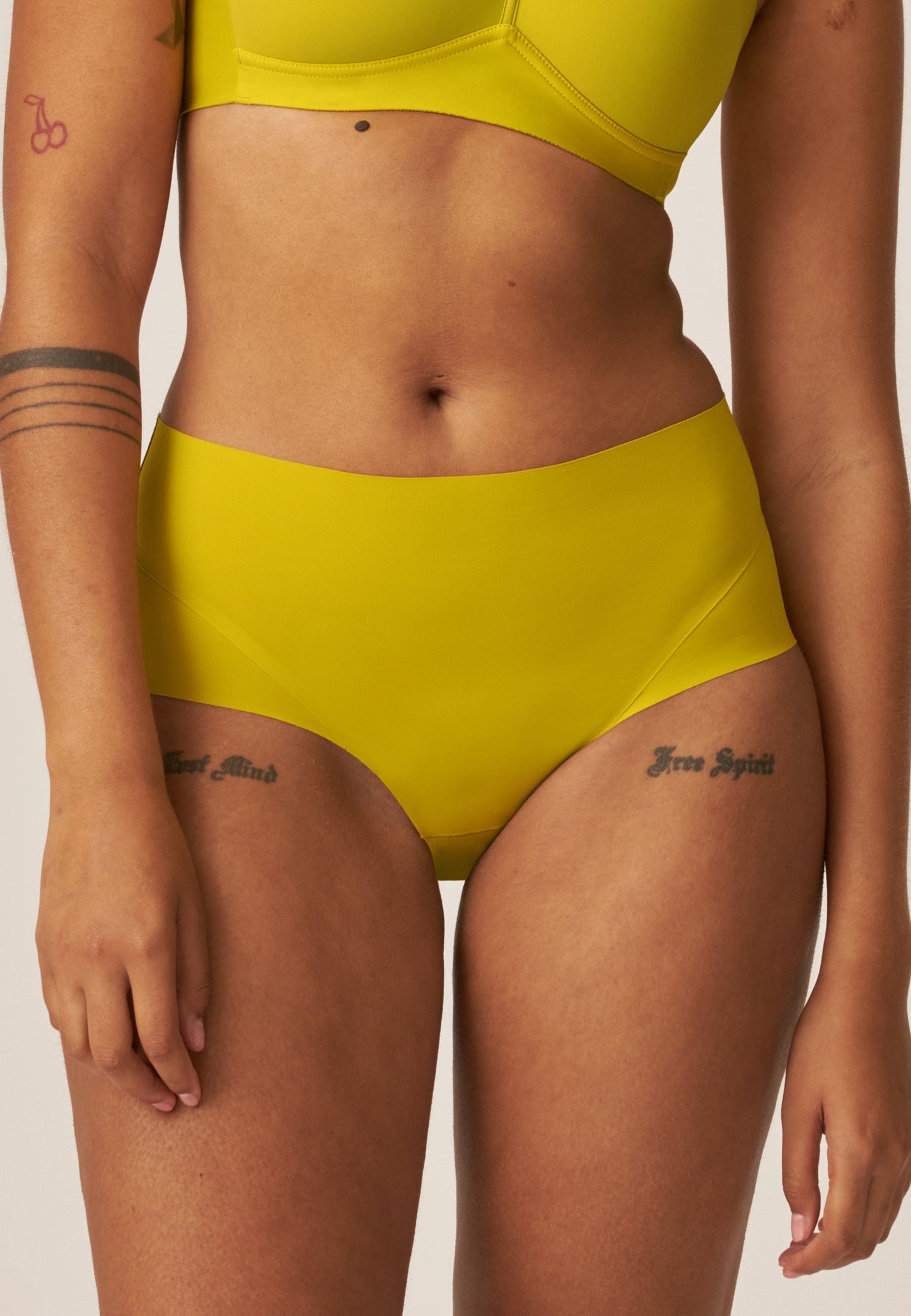 Voorzijde van vrouw die de side smoother bh en high waist slip in de kleur golden olive van het merk Naturana draagt