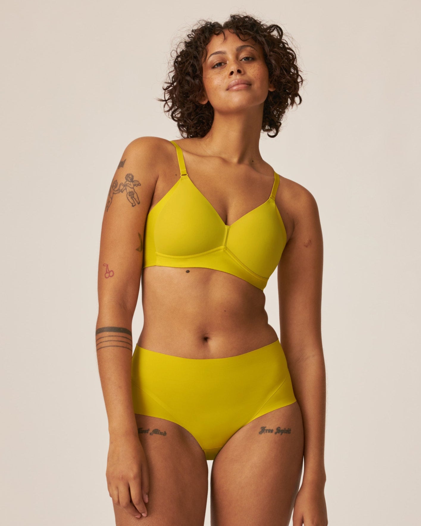 Voorzijde van vrouw die de side smoother bh en high waist slip in de kleur golden olive van het merk Naturana draagt