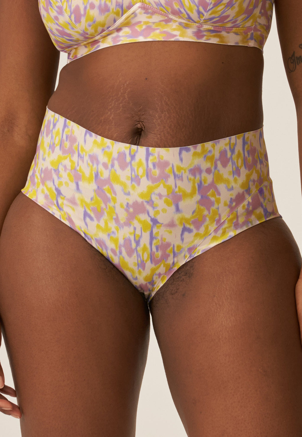 Voorzijde van vrouw die de side smoother bh en high waist slip in de kleur smoked orchid print van het merk Naturana draagt