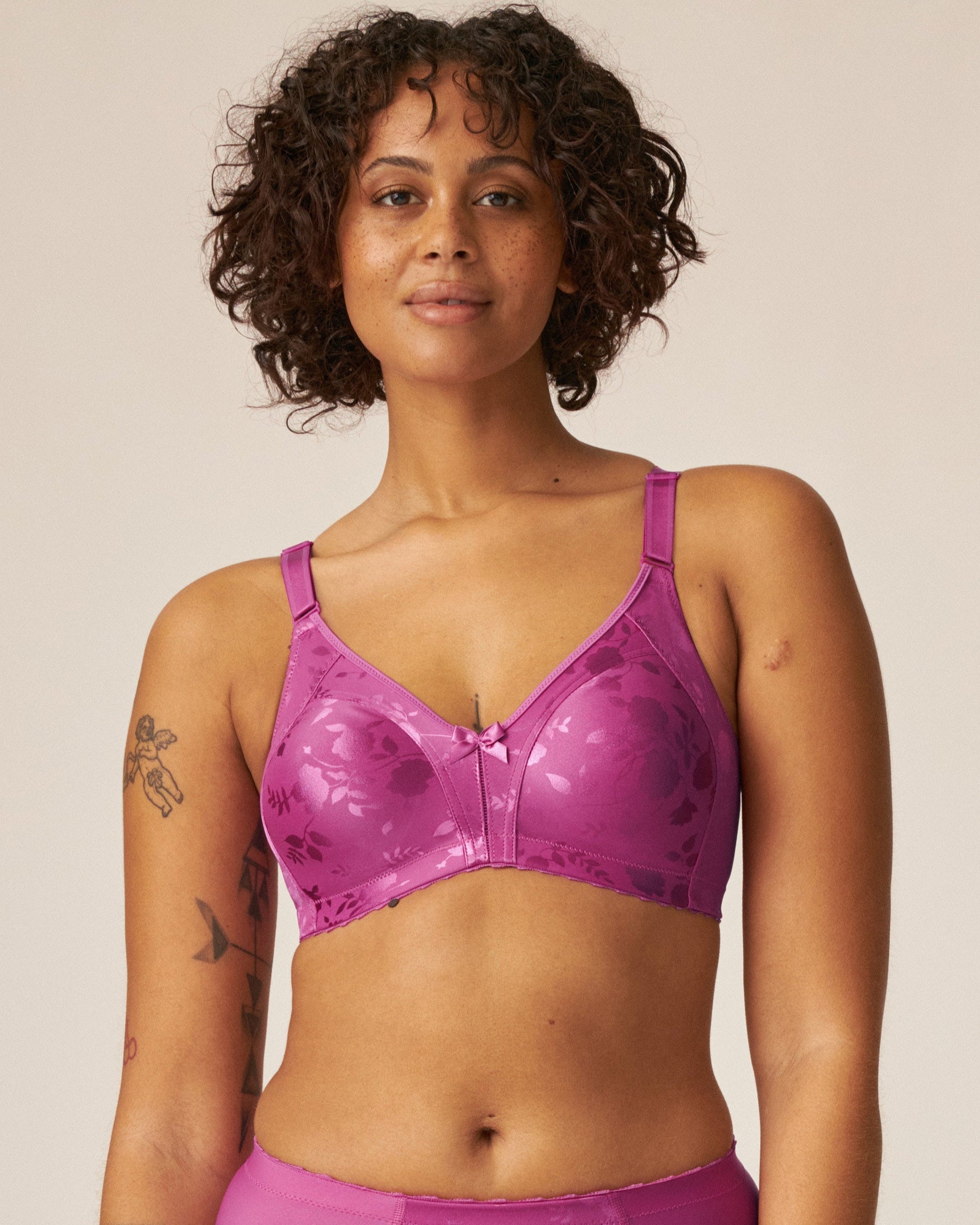 Voorzijde van vrouw die de minimizer bh met bloemenpatroon en slip met bloemenpatroon in de kleur Purple Orchid van het merk Naturana draagt
