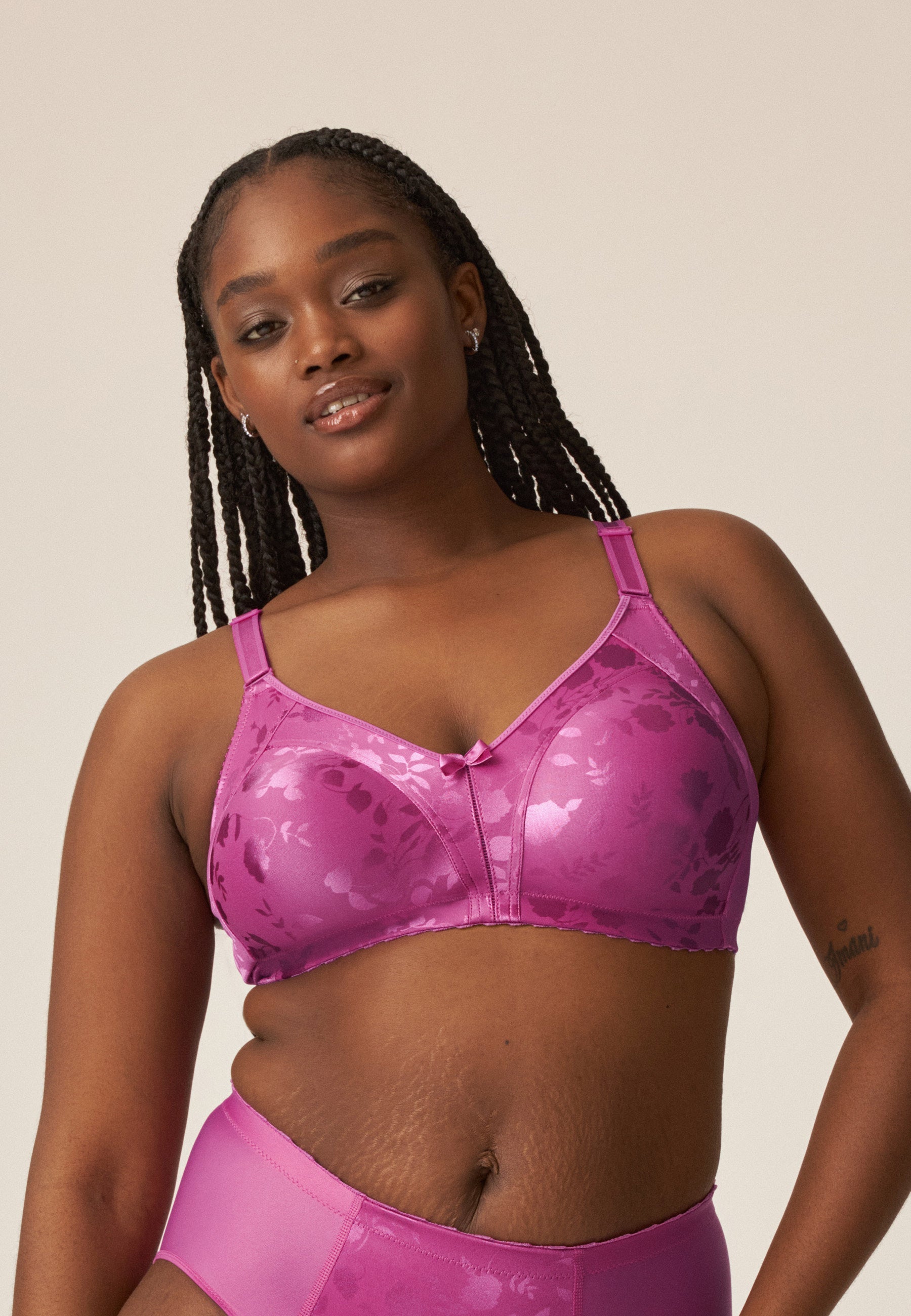 Voorzijde van vrouw die de minimizer bh met bloemenpatroon en slip met bloemenpatroon in de kleur Purple Orchid van het merk Naturana draagt