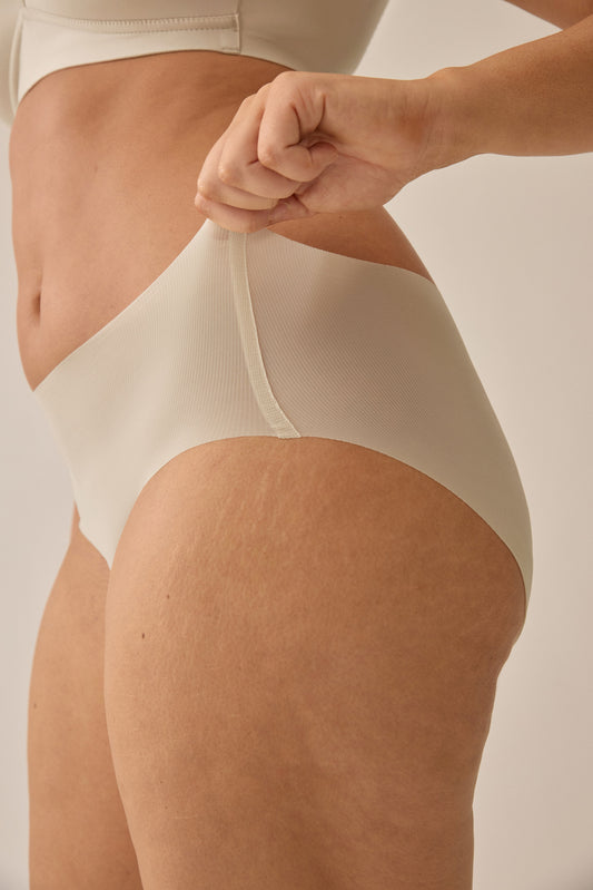Zijde van vrouw die de slip one size in de kleur beige van het merk Naturana draagt