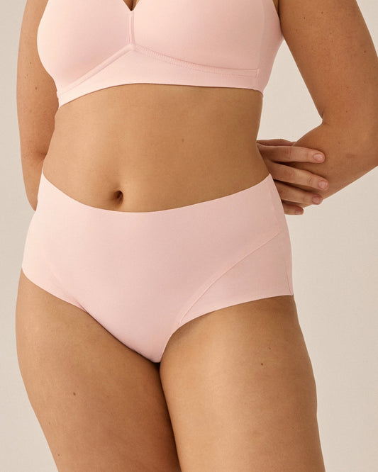 Voorzijde van vrouw die de side smoother bh en high waist slip in de kleur blush van het merk Naturana draagt