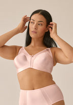 Voorzijde van vrouw die de minimizer bh met glanzend patroon in de kleur blush van het merk Naturana draagt