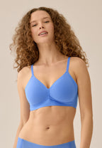 Voorzijde van vrouw die de side smoother bh zonder beugel in de kleur marina blue van het merk Naturana draagt