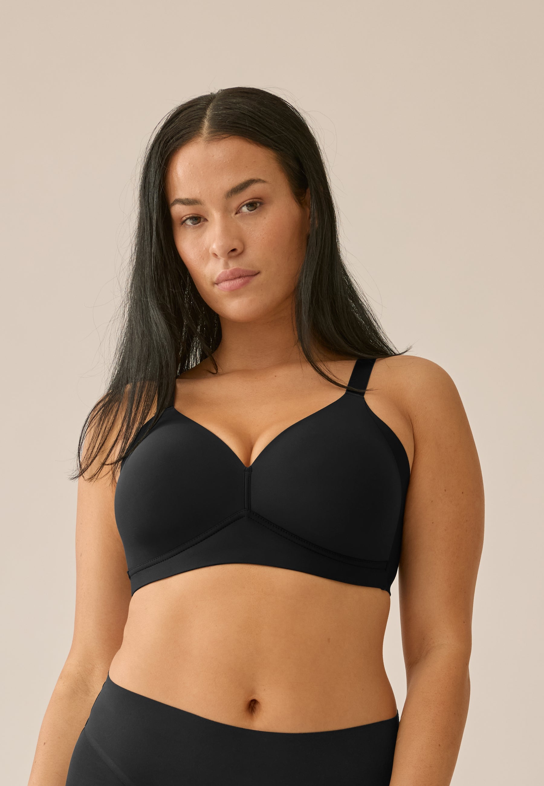 Voorzijde van vrouw die de side smoother bh zonder beugel in de kleur zwart van het merk Naturana draagt