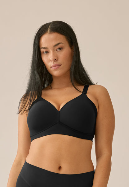 Voorzijde van vrouw die de side smoother bh zonder beugel in de kleur zwart van het merk Naturana draagt