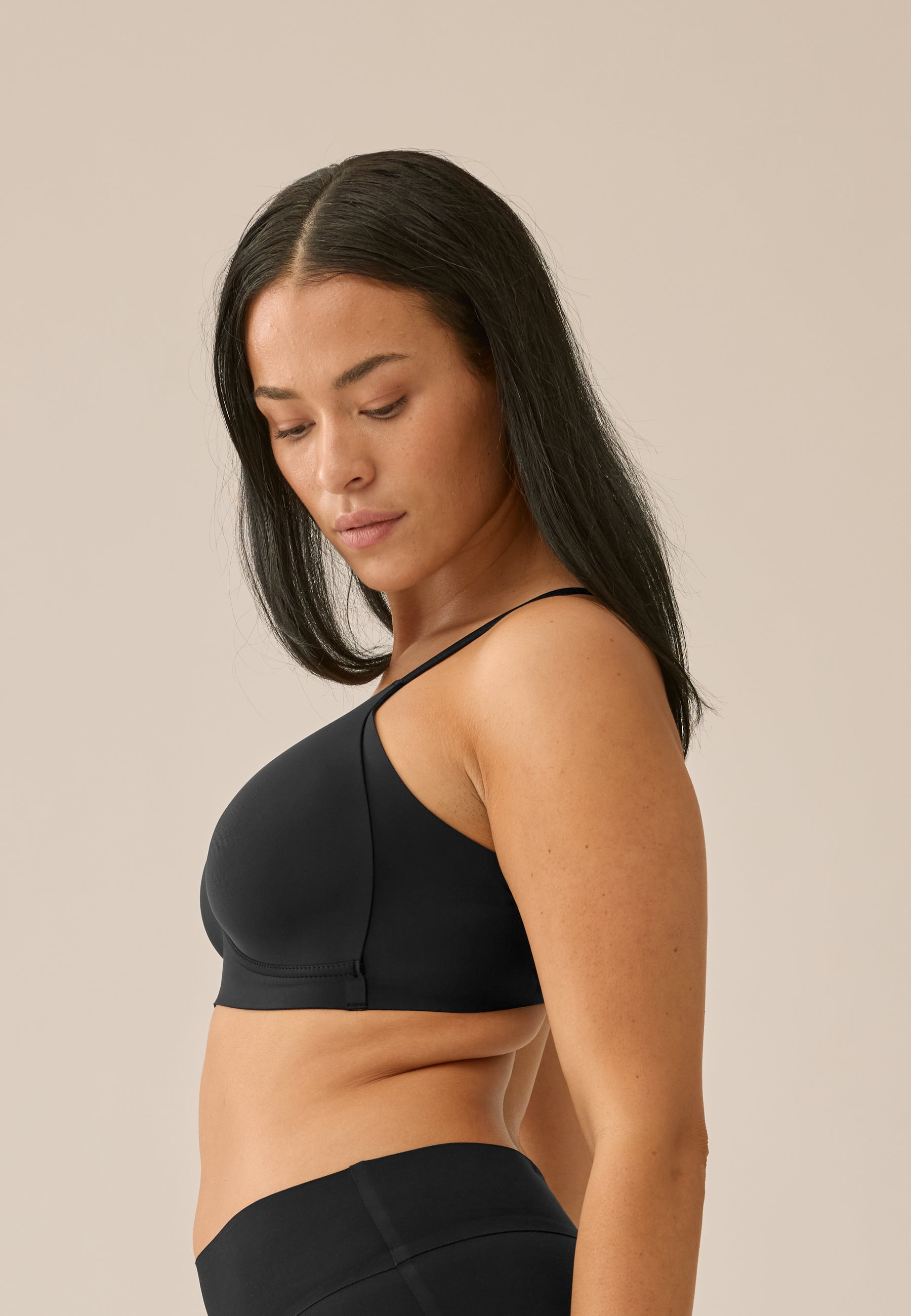 Zijde van vrouw die de side smoother bh in de kleur zwart van het merk Naturana draagt