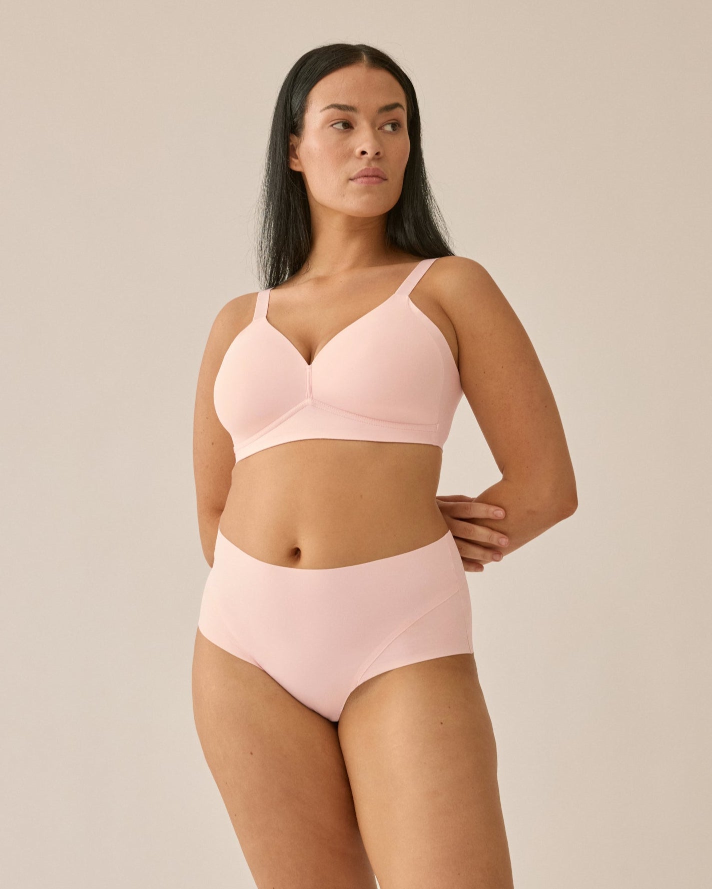 Voorzijde van vrouw die de side smoother bh en high waist slip in de kleur blush van het merk Naturana draagt
