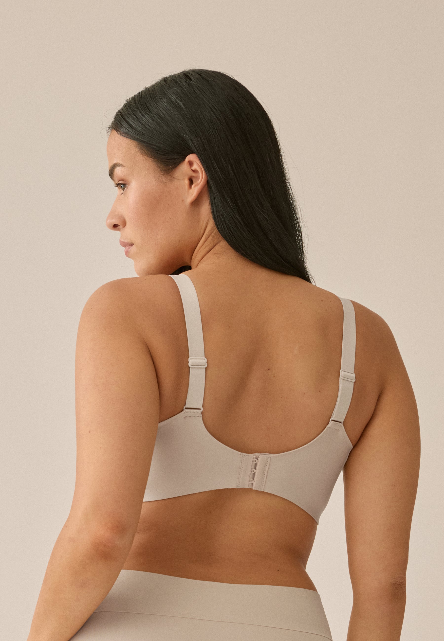 Achterzijde van vrouw die de side smoother bh in de kleur beige van het merk Naturana draagt