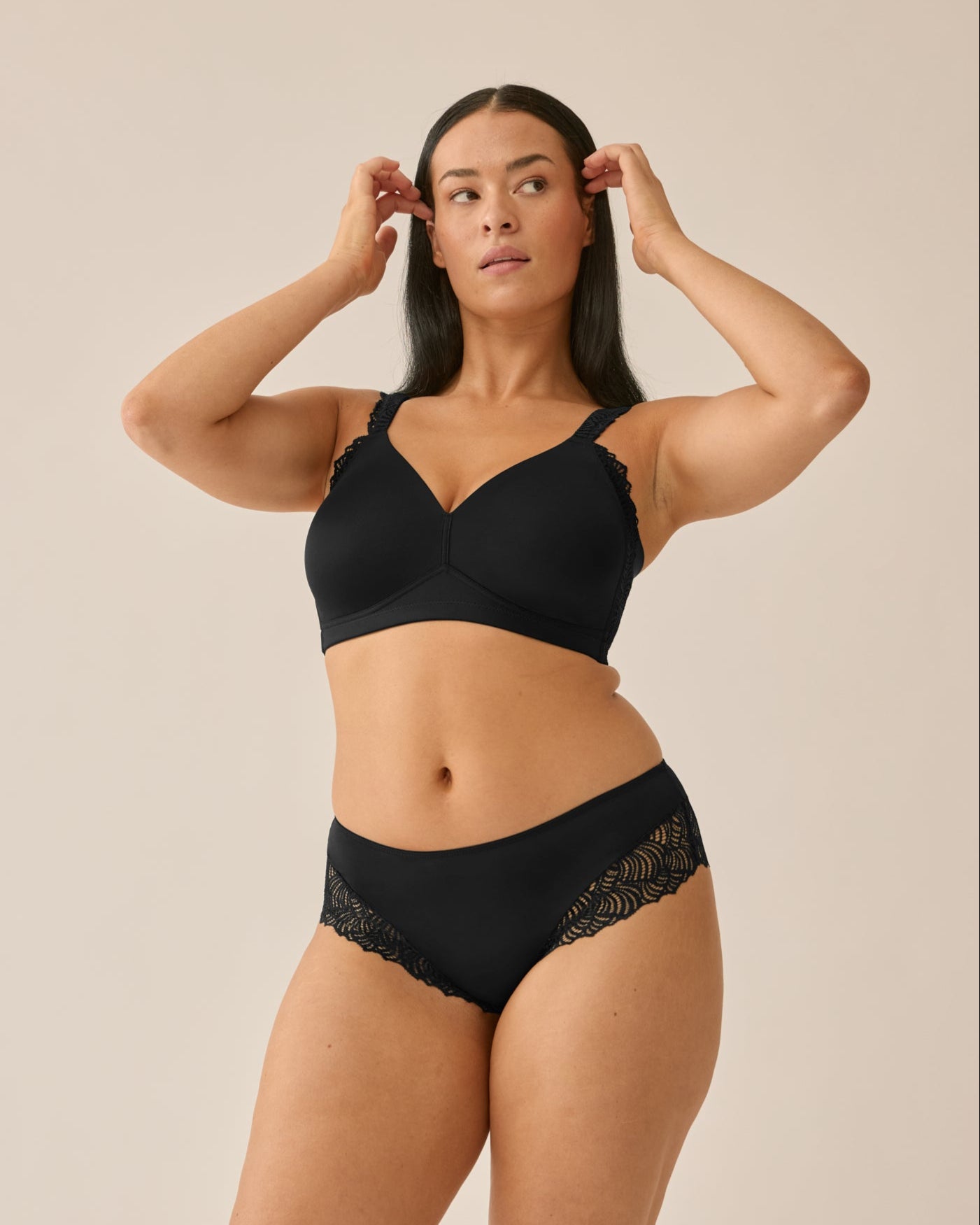 Voorzijde van vrouw die de side smoother bh met kant en hipster met kant in de kleur zwart van het merk Naturana draagt