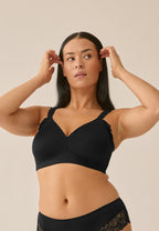 Voorzijde van vrouw die de side smoother bh met kant in de kleur zwart van het merk Naturana draagt