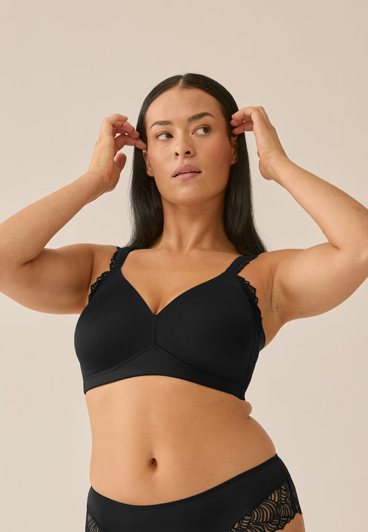 Voorzijde van vrouw die de side smoother bh met kant in de kleur zwart van het merk Naturana draagt