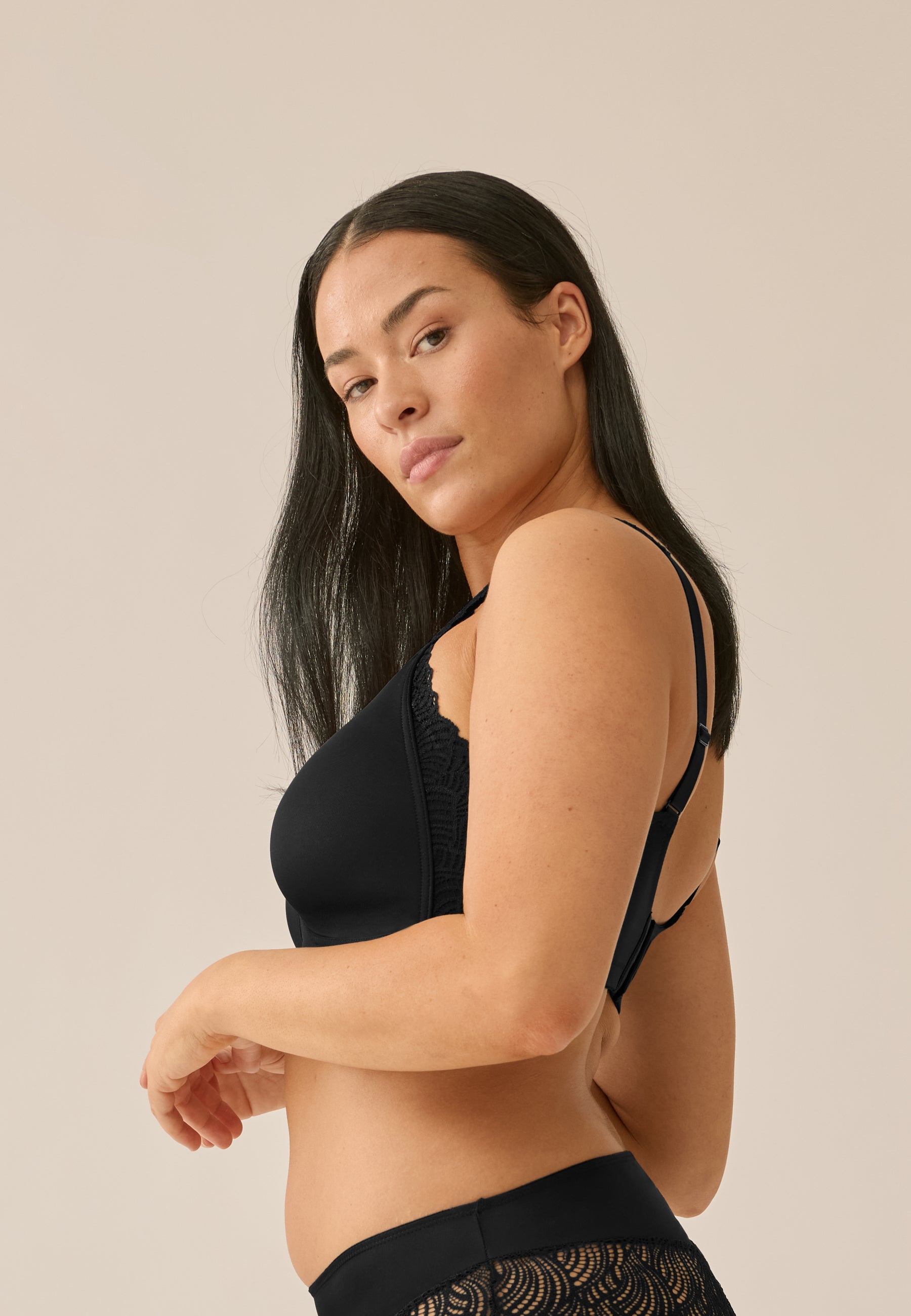 Zijde van vrouw die de side smoother bh met kant in de kleur zwart van het merk Naturana draagt