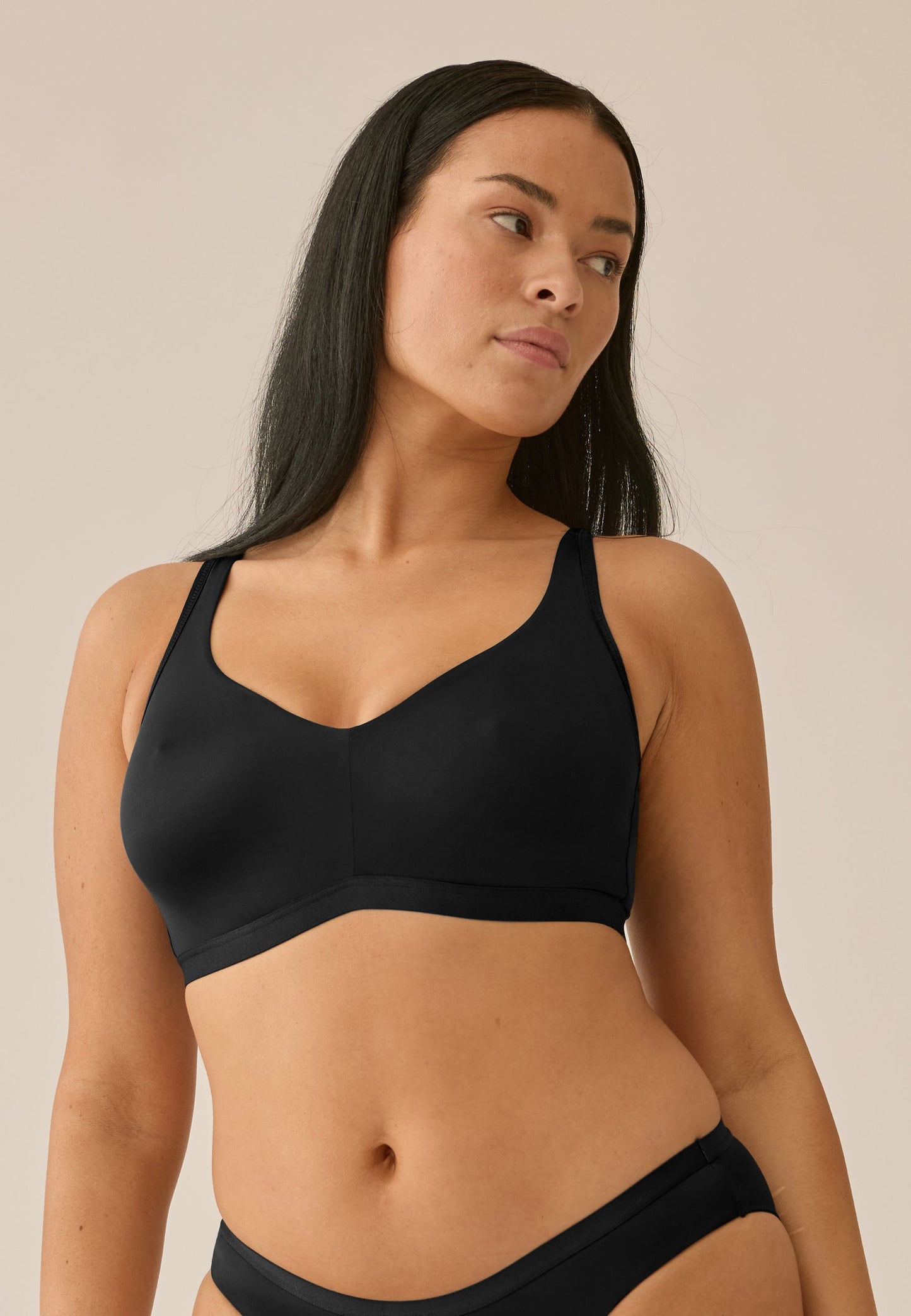 Voorzijde van vrouw die de minimizer bh en slip in de kleur zwart van het merk Naturana draagt