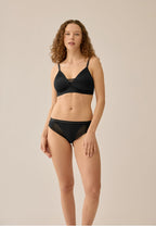 Voorzijde van vrouw die de voorgevormde soft bh met mesh detail in de kleur zwart van het merk Naturana draagt