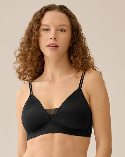 Voorzijde van vrouw die de voorgevormde soft bh met mesh detail in de kleur zwart van het merk Naturana draagt