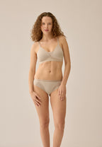 Voorzijde van vrouw die de voorgevormde soft bh met mesh detail in de kleur beige van het merk Naturana draagt