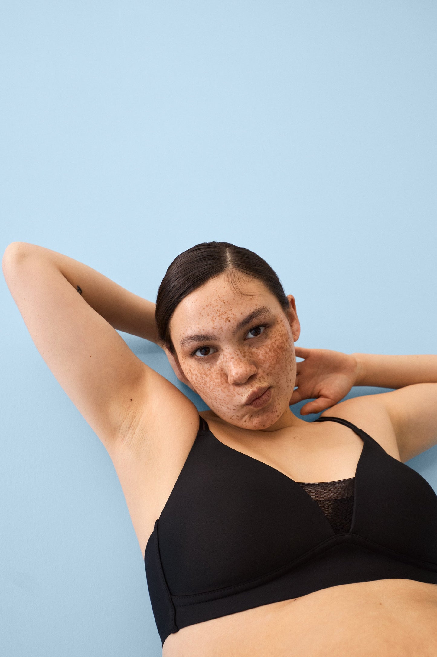 Voorzijde van vrouw die de voorgevormde soft bh met mesh detail in de kleur zwart van het merk Naturana draagt