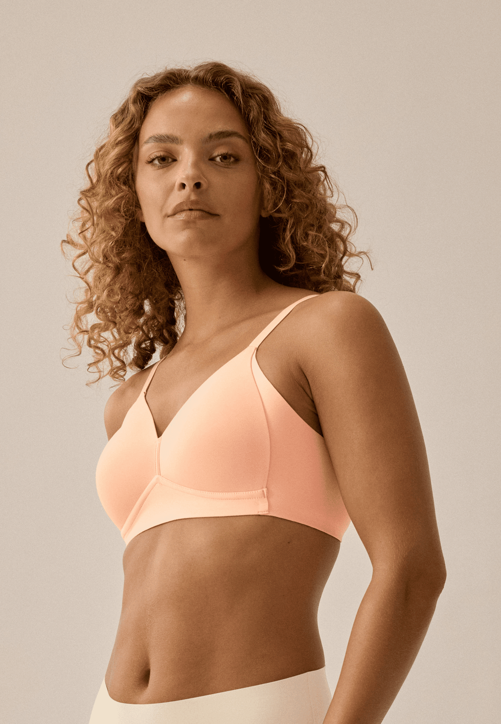 Zijde van vrouw die de side smoother bh in de kleur sunset van het merk Naturana draagt