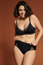 Voorzijde van vrouw die de soft bh met mesh detail en de slip met mesh detail in de kleur zwart van het merk Naturana draagt