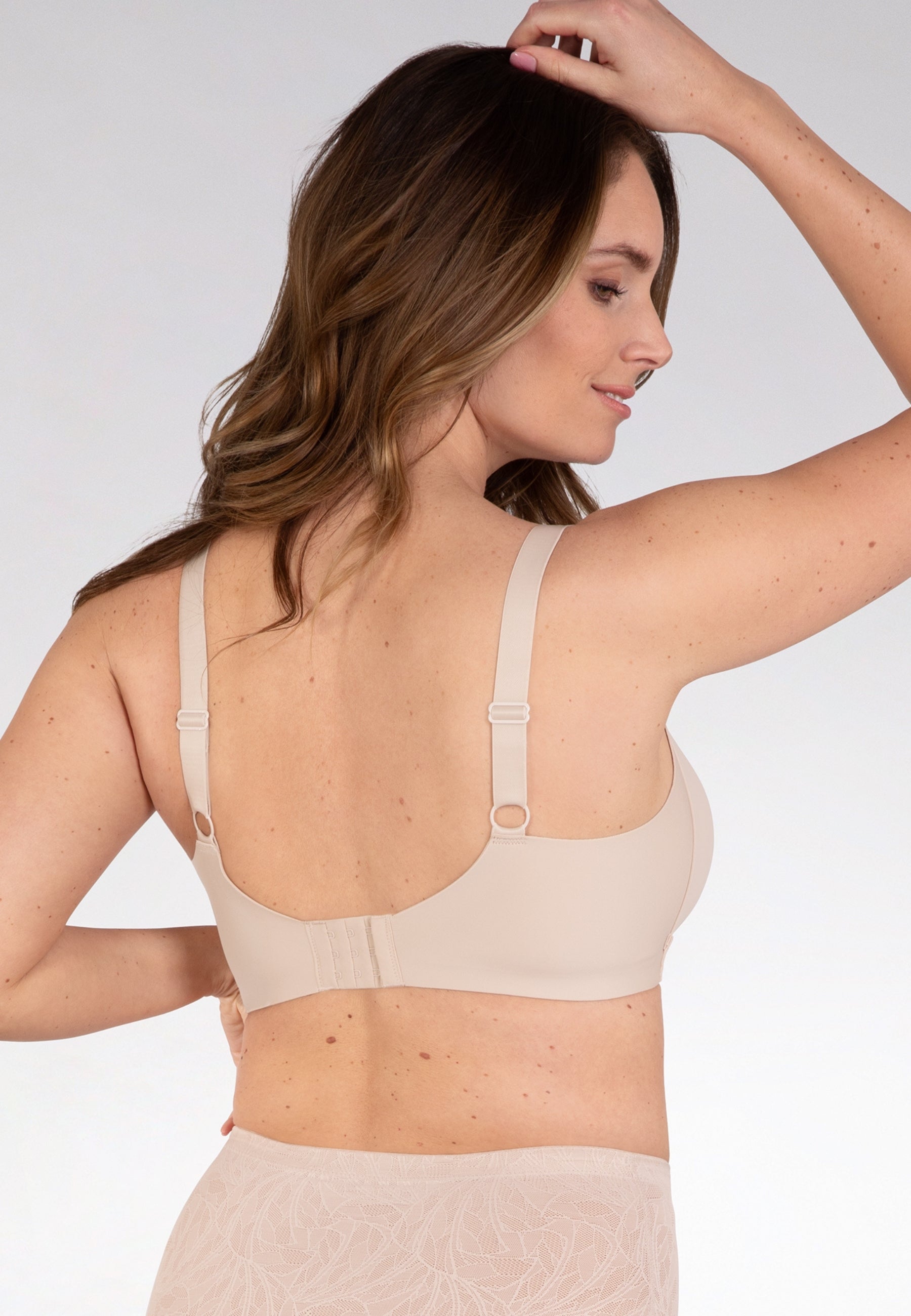 Achterzijde van vrouw die de side smoother bh in de kleur beige van het merk Naturana draagt