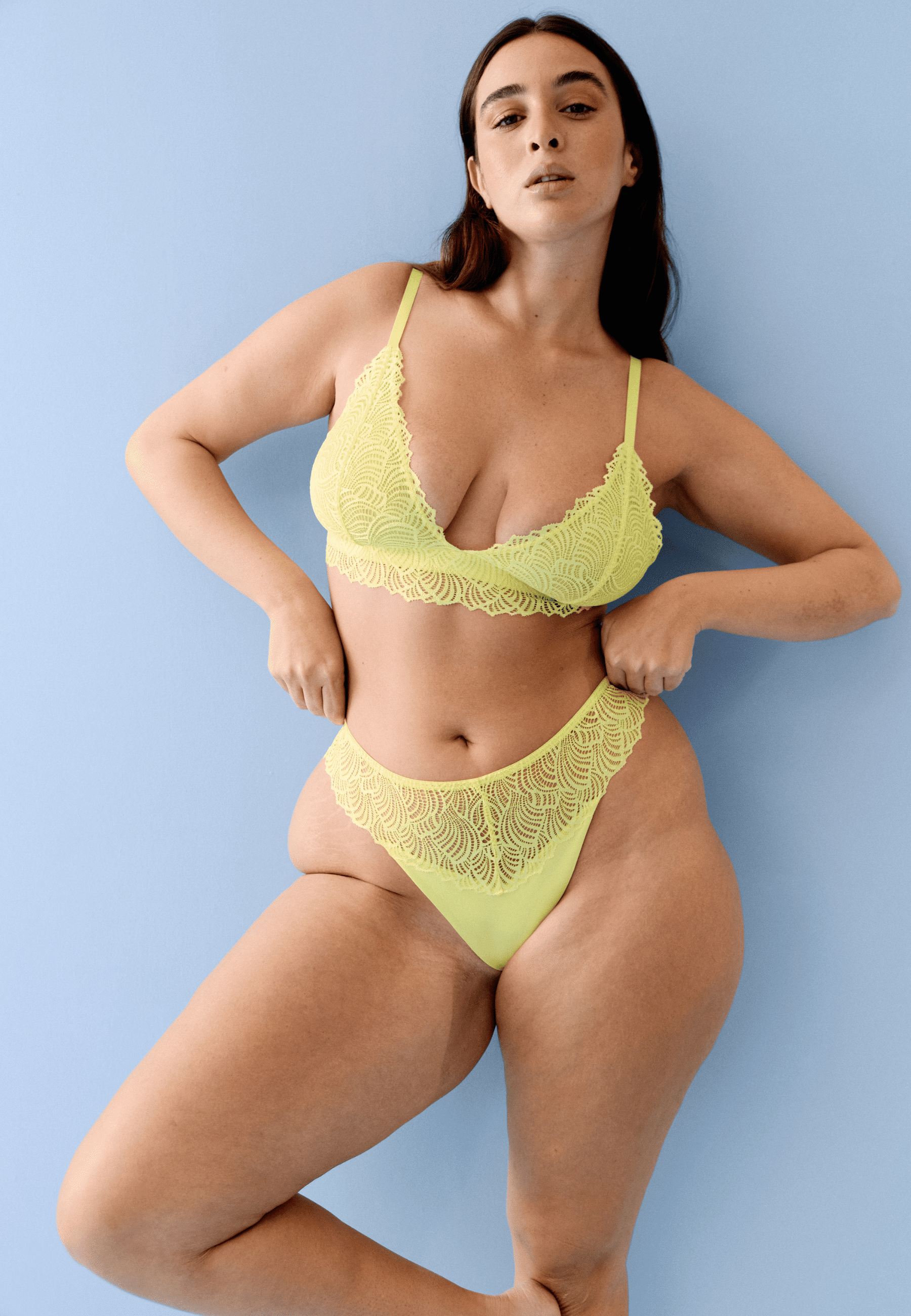 Voorzijde van vrouw die de bralette met gerecycled kant en string met gerecycled kant in de kleur sunny lime van het merk Naturana draagt
