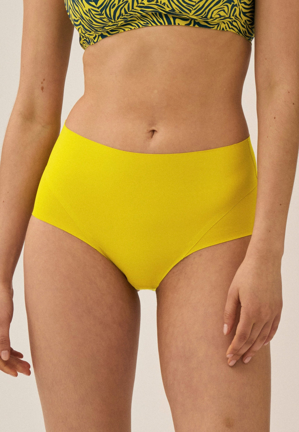 Voorzijde van vrouw die de high waist slip in de kleur golden olive van het merk Naturana draagt
