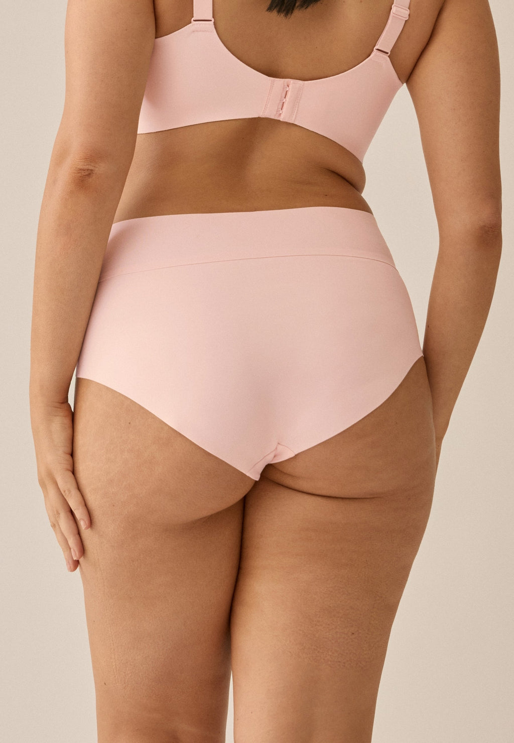 Achterzijde van vrouw die de high waist slip in de kleur blush van het merk Naturana draagt