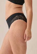 Zijde van vrouw die de hipster met gerecycled kant in de kleur zwart van het merk Naturana draagt