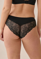 Achterzijde van vrouw die de hipster met gerecycled kant in de kleur zwart van het merk Naturana draagt