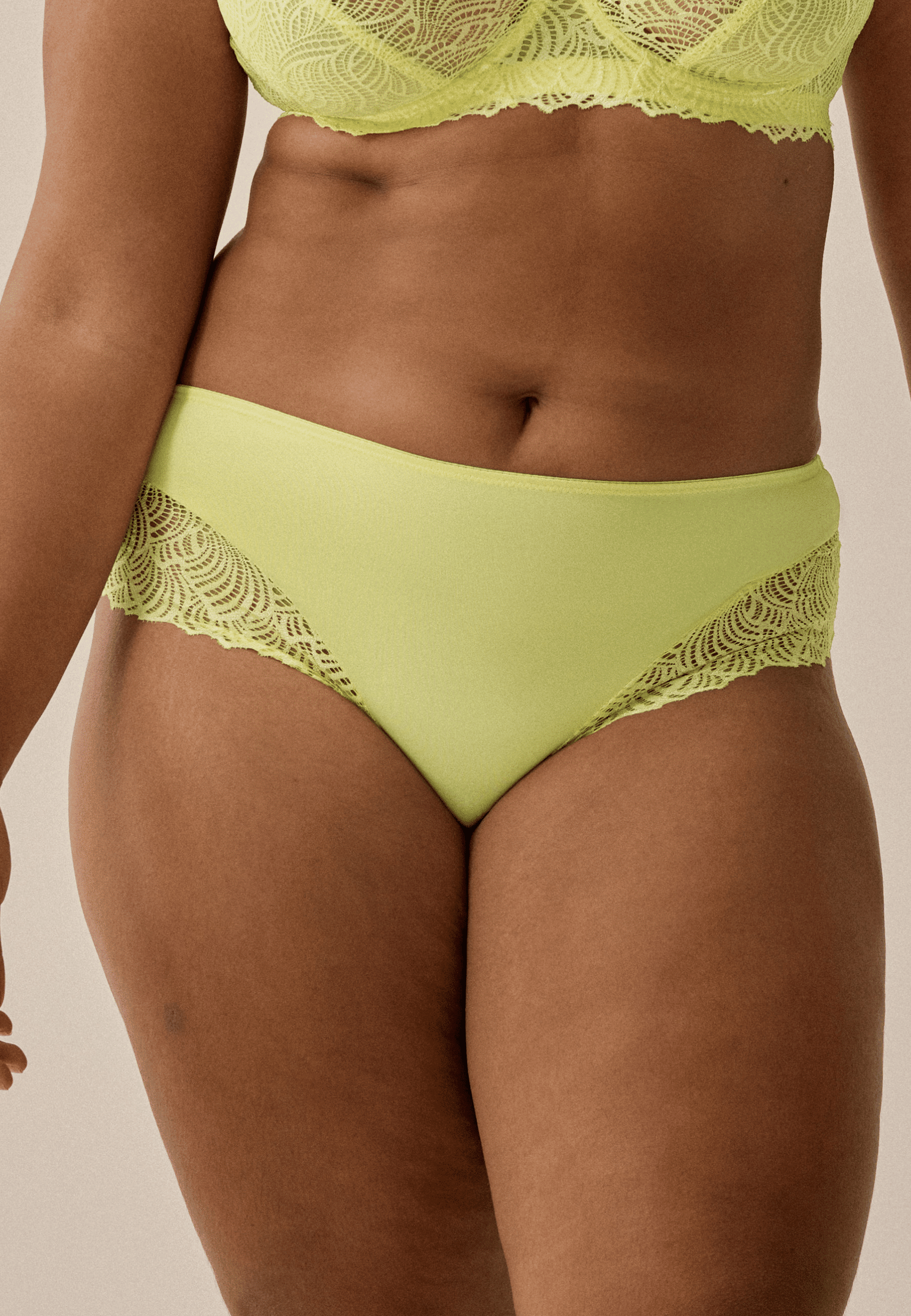 Voorzijde van vrouw die de hipster met gerecycled kant in de kleur sunny lime van het merk Naturana draagt