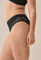 Zijde van vrouw die de hipster met gerecycled kant in de kleur zwart van het merk Naturana draagt