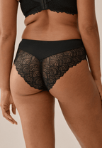 Achterzijde van vrouw die de hipster met gerecycled kant in de kleur zwart van het merk Naturana draagt