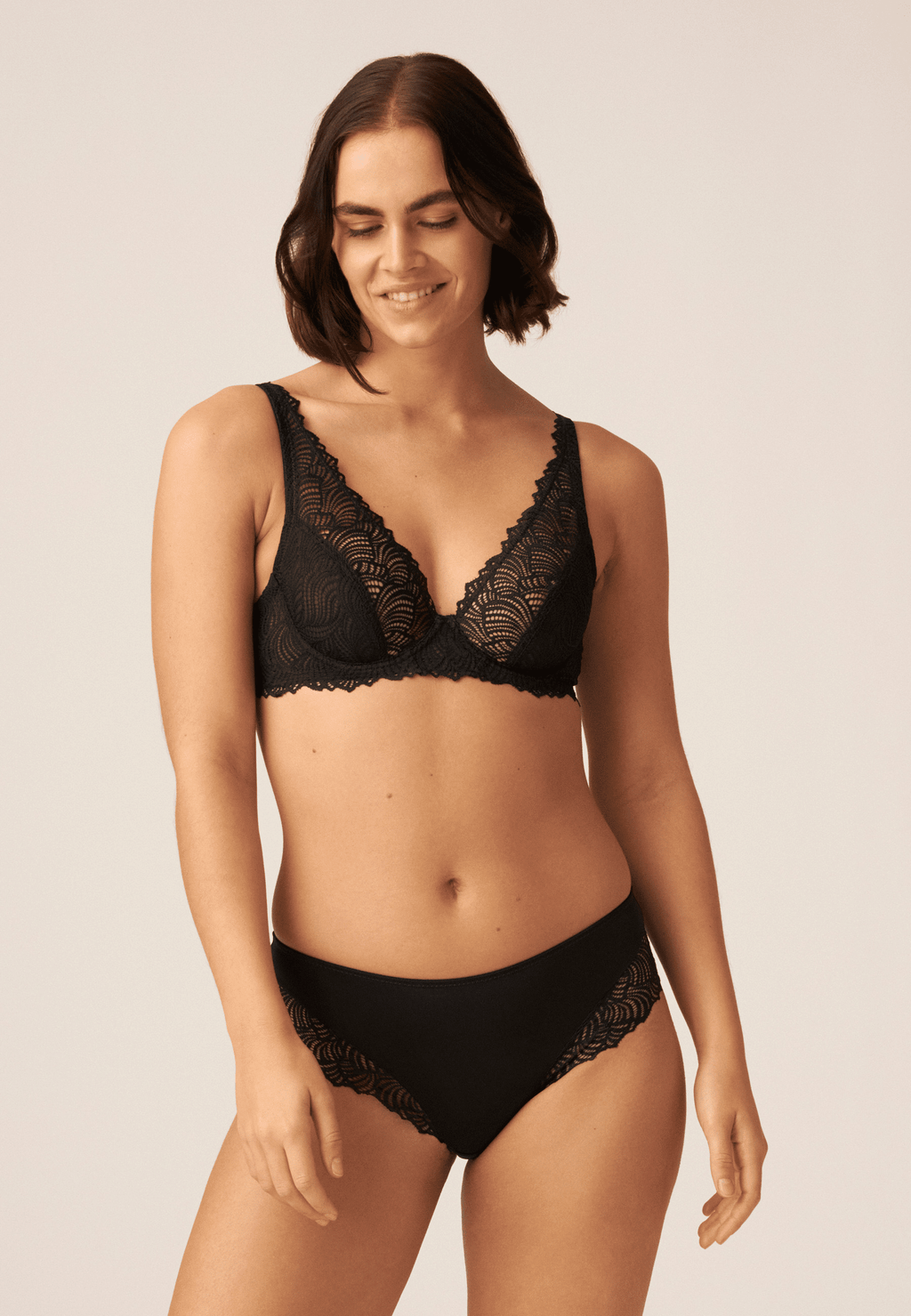 Voorzijde van vrouw die de hipster met gerecycled kant in de kleur zwart van het merk Naturana draagt