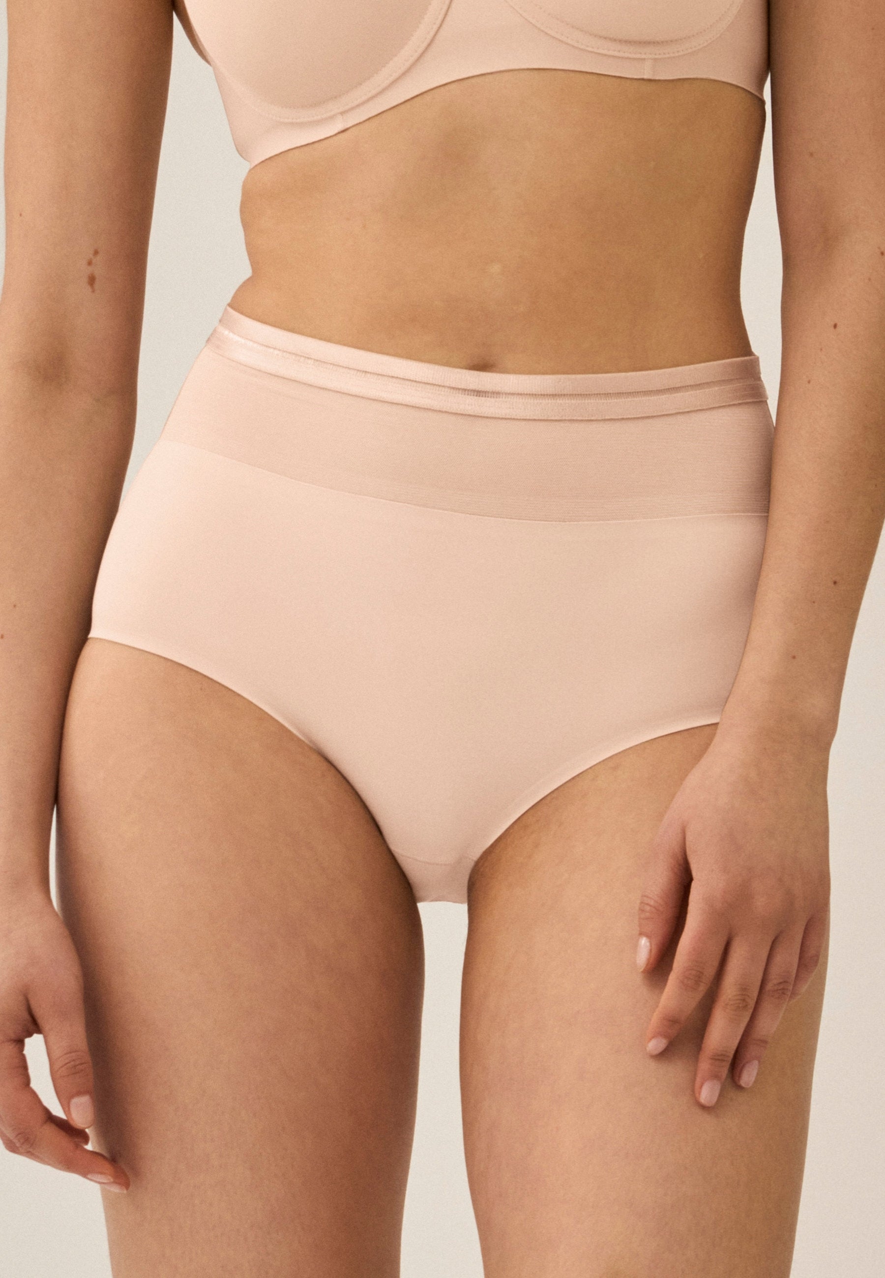 Voorzijde van vrouw die de hoge slip met mesh detail in de kleur beige van het merk Naturana draagt