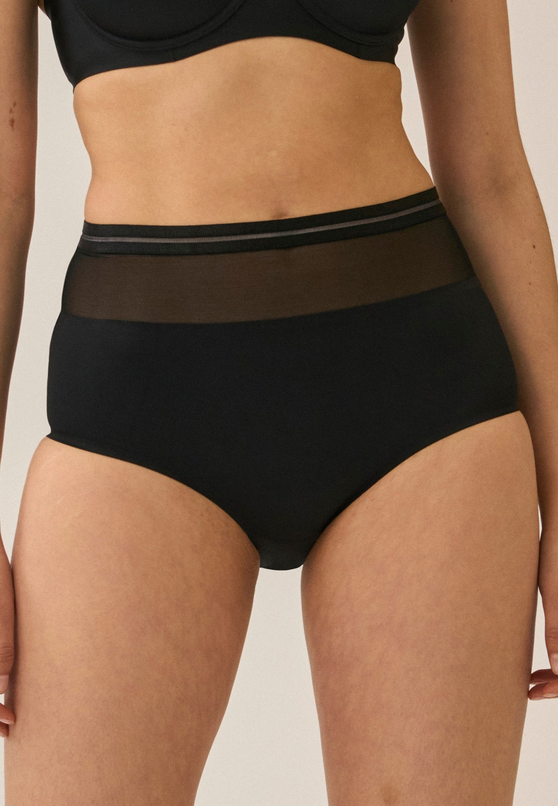 Voorzijde van vrouw die de hoge slip met mesh detail in de kleur zwart van het merk Naturana draagt
