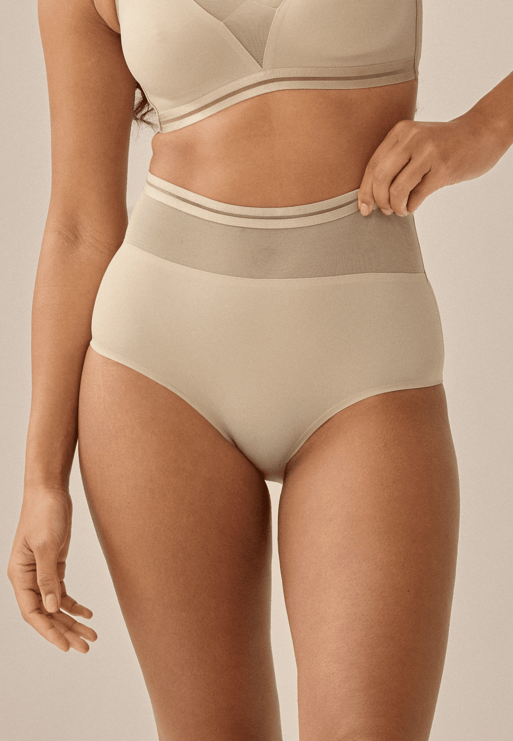 Voorzijde van vrouw die de hoge slip met mesh in de kleur beige van het merk Naturana draagt