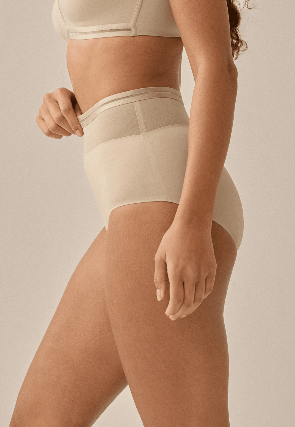 Zijde van vrouw die de hoge slip met mesh in de kleur beige van het merk Naturana draagt