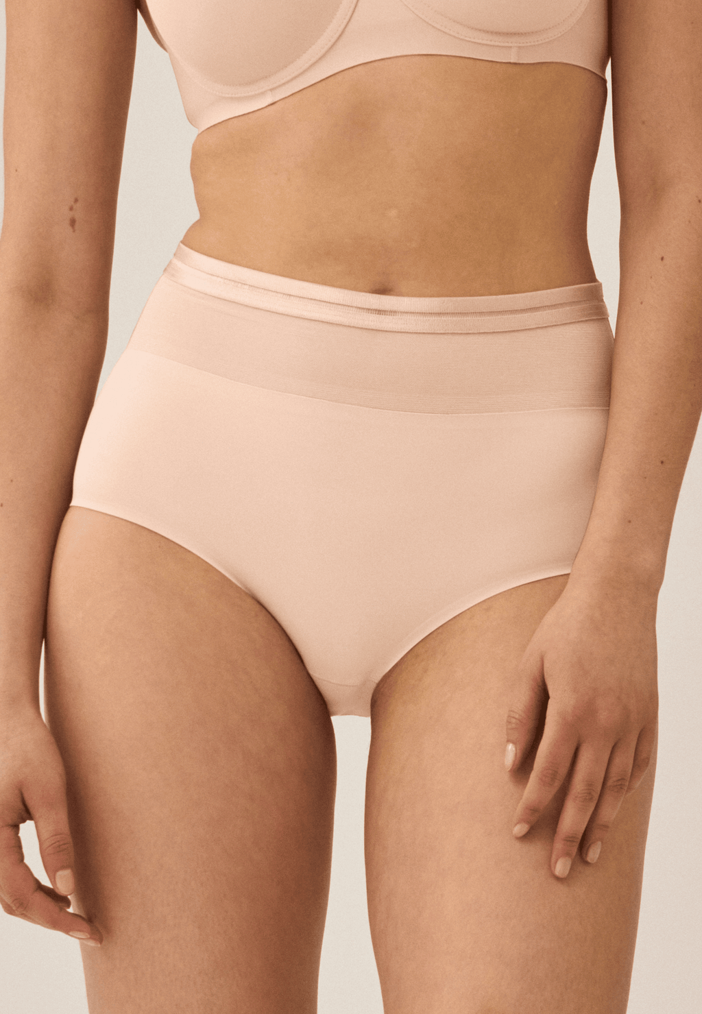 Voorzijde van vrouw die de hoge slip met mesh in de kleur beige van het merk Naturana draagt