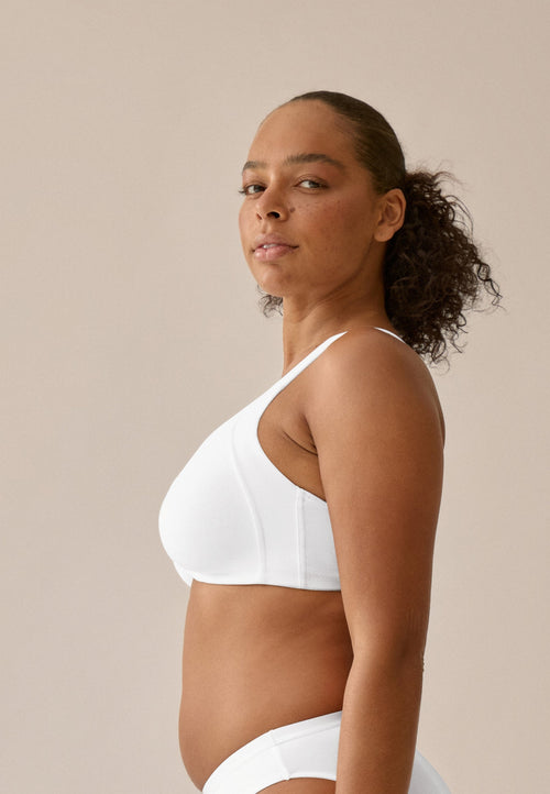 Zijde van vrouw die de katoenen minimizer bh met side smoother in de kleur wit van het merk Naturana draagt