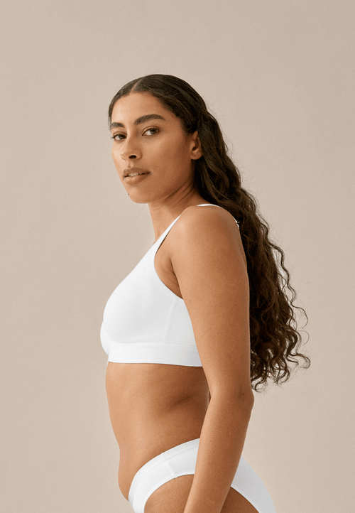 Zijde van vrouw die de katoenen soft bh in de kleur wit van het merk Naturana draagt