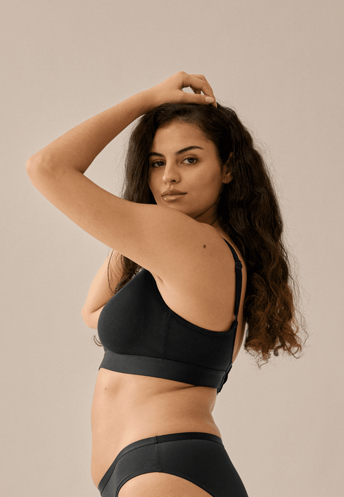 Zijde van vrouw die de katoenen soft bh in de kleur zwart van het merk Naturana draagt