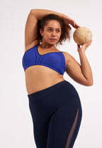 Voorzijde van vrouw die de minimizer bh met side smoother in de kleur indigo van het merk Naturana draagt